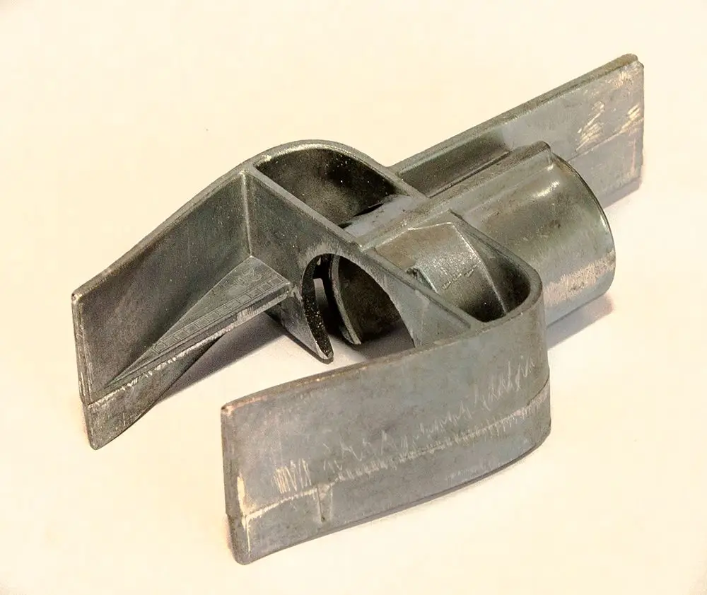 Metallisches Bauteil mit einer komplexen Form, vermutlich für die Verbindung von Luft und Gas in Heizsystemen, möglicherweise von der Marke Daikin.